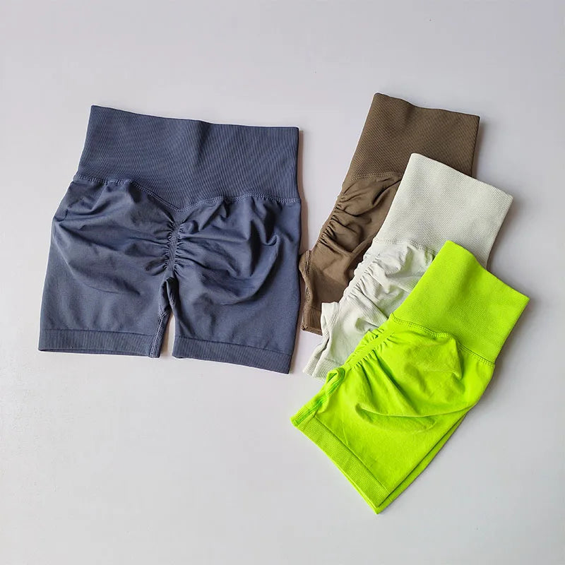 Four pairs of shorts in blue, brown, white, and green on a gray background